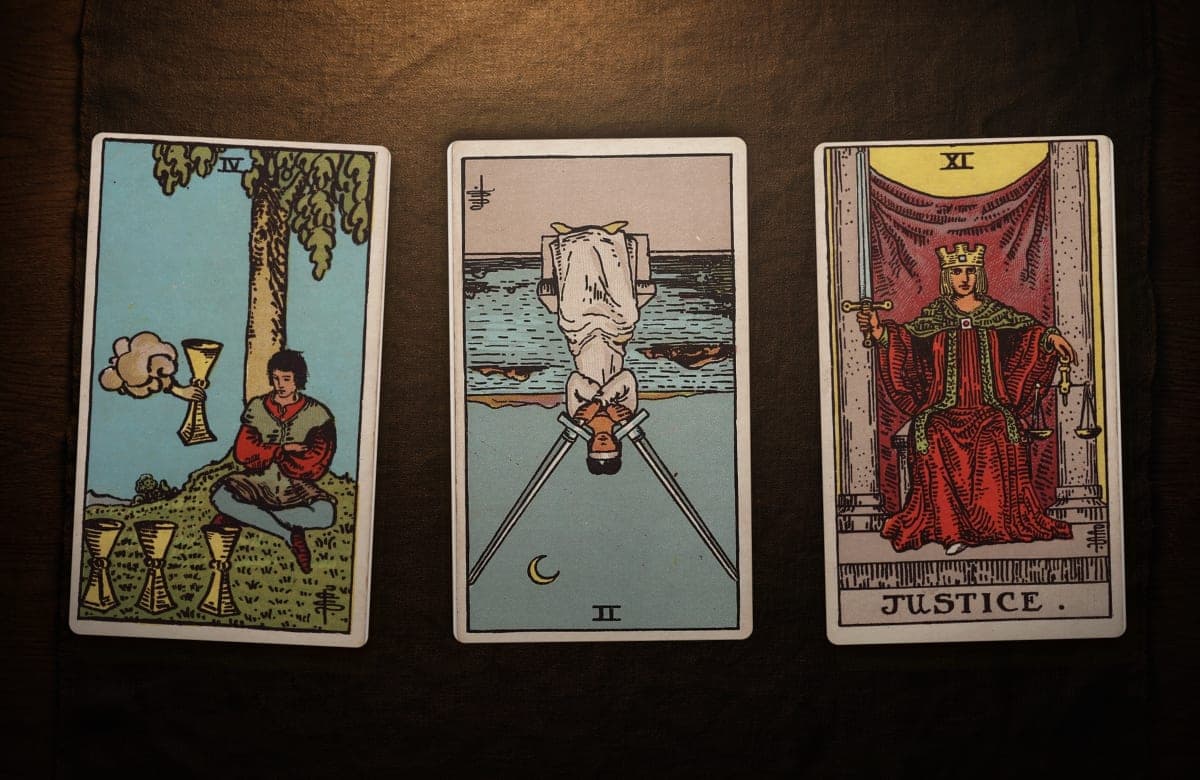 Ejemplo de tirada de tarot: PASADO: Cuatro de Copas (al derecho) · PRESENTE: Dos de Espadas (en posición invertida) · FUTURO: La Justicia (al derecho)