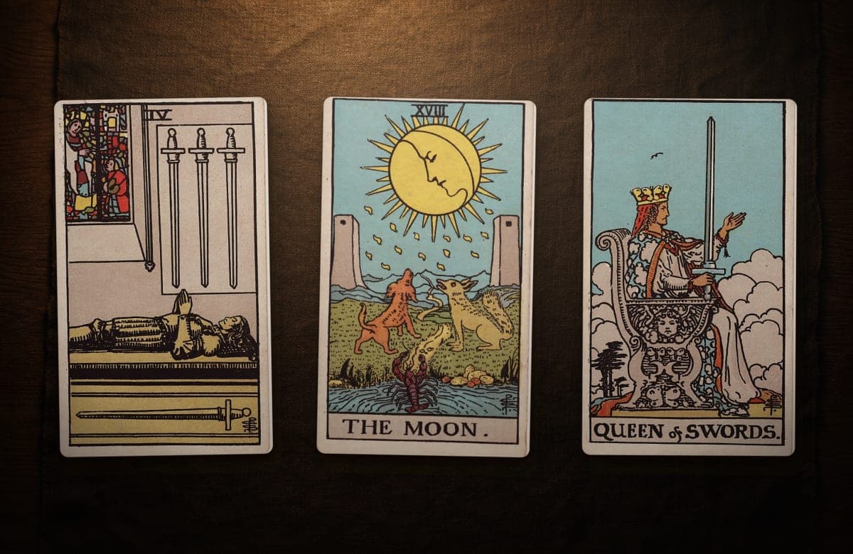 Ejemplo de tirada de tarot: PASADO: Cuatro de Espadas (al derecho) · PRESENTE: La Luna (al derecho) · FUTURO: Reina de Espadas (al derecho)